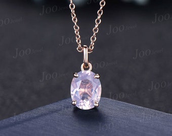 May include: A rose gold chain necklace with a pendant featuring a large oval-shaped pink gemstone.