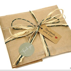 May include: A wrapped package in brown paper, tied with natural raffia and green and gold twine. A small tag reads "Handmade with Love" and a round sticker says "Thank you". The package is ready for gifting.