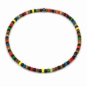 May include: A colourful beaded necklace featuring a variety of beads in shades of red, yellow, green, blue, and black. The necklace is circular and made of small, round beads. The beads are strung together to form a necklace.