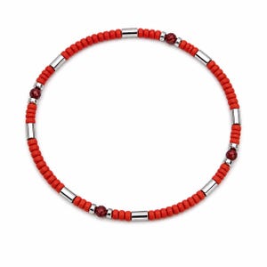 May include: Red beaded necklace with silver-tone metal accents and small, round, red gemstones. The necklace features a series of small, round red beads, interspersed with silver-tone cylindrical beads and red gemstones.