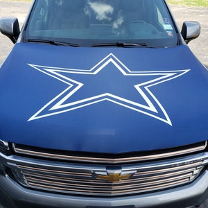 May include: A blue car cover with a white star design. The star has a double outline.