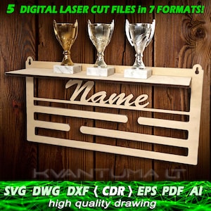 Può includere: Un ripiano per trofei in legno tagliato al laser con una targhetta che dice "Nome". Il ripiano ha tre slot per trofei ed è progettato per essere montato a parete. Il ripiano è in legno marrone chiaro e ha una finitura naturale. L'immagine include anche tre trofei dorati e argentati.