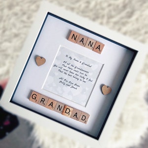 May include: A white picture frame with a white mat and a light gray background. The frame contains a poem about grandparents and the words "NANA" and "GRANDAD" spelled out with wooden letter tiles. The poem reads: "To My Nana & Grandad Of all the Grandparents That there could ever be You will never know how lucky I feel That the best belong to me. All Our Love From Holly and Jonah"
