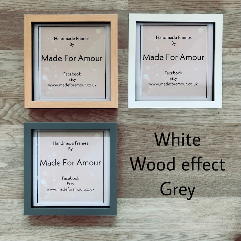 Pu&ograve; includere: Tre cornici quadrate per foto con sfondo bianco e testo che recita "Handmade Frames By Made For Amour Facebook Etsy www.madeforamour.co.uk". Le cornici sono di tre colori diversi: legno naturale, bianco e grigio.