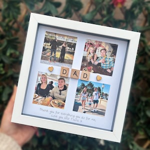 Pode incluir: Uma colagem de fotos emoldurada em branco com quatro fotos, letras de madeira que soletram "DAD" e detalhes em forma de cora&ccedil;&atilde;o. A parte inferior da moldura tem o texto manuscrito: "Thank you for everything you do for me, Love you lots! Tsara x."