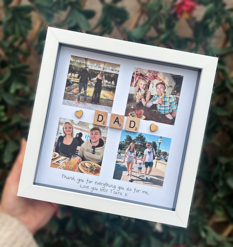 Pode incluir: Uma colagem de fotos emoldurada em branco com quatro fotos, letras de madeira que soletram "DAD" e detalhes em forma de cora&ccedil;&atilde;o. A parte inferior da moldura tem o texto manuscrito: "Thank you for everything you do for me, Love you lots! Tsara x."