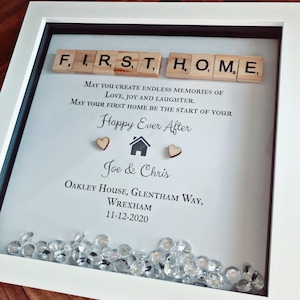 Pu&ograve; includere: Una cornice bianca con un passepartout bianco e un bordo nero. La cornice contiene uno sfondo bianco con le parole "FIRST HOME" scritte con tessere di lettere di legno. Il testo "MAY YOU CREATE ENDLESS MEMORIES OF LOVE, JOY AND LAUGHTER. MAY YOUR FIRST HOME BE THE START OF YOUR Happy Ever After" &egrave; stampato sotto le tessere. I nomi "Joe & Chris" sono stampati sotto il testo, seguiti dall'indirizzo "OAKLEY HOUSE, GLENTHAM WAY, WREXHAM 11-12-2020". La cornice &egrave; decorata con piccole gemme di plastica trasparente.