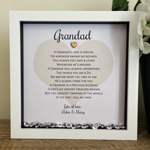 May include: A white framed picture with a heart-shaped beige background and a poem about a grandad's love. The poem reads "A Grandad's love is special, His kindness knows no bounds..." and is signed "Lots of love, Asha & Macy".