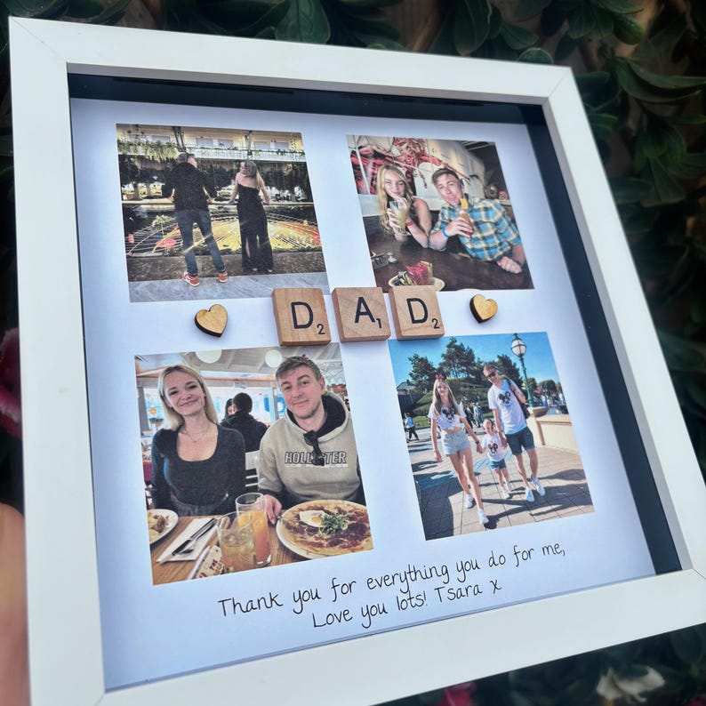 Pode incluir: Uma colagem de fotos emoldurada em branco com quatro fotos, letras de madeira que soletram "DAD" e dois cora&ccedil;&otilde;es de madeira. A parte inferior da colagem tem texto manuscrito: "Thank you for everything you do for me, Love you lots! T Sara x".