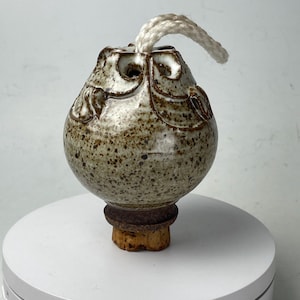 May include: A set of three ceramic mugs with a speckled, matte finish. Each mug features a different color: light blue, cream, and gray. The mugs have a minimalist design with a rounded shape and a comfortable handle.