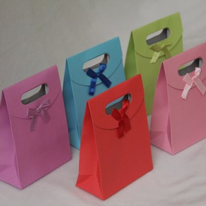May include: Five small gift bags with different colored paper and ribbon bows. The bags are pink, red, blue, green, and light pink.
