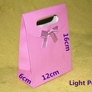 May include: Light purple gift bag with a bow, measuring 6 inches by 12 inches by 16 inches.