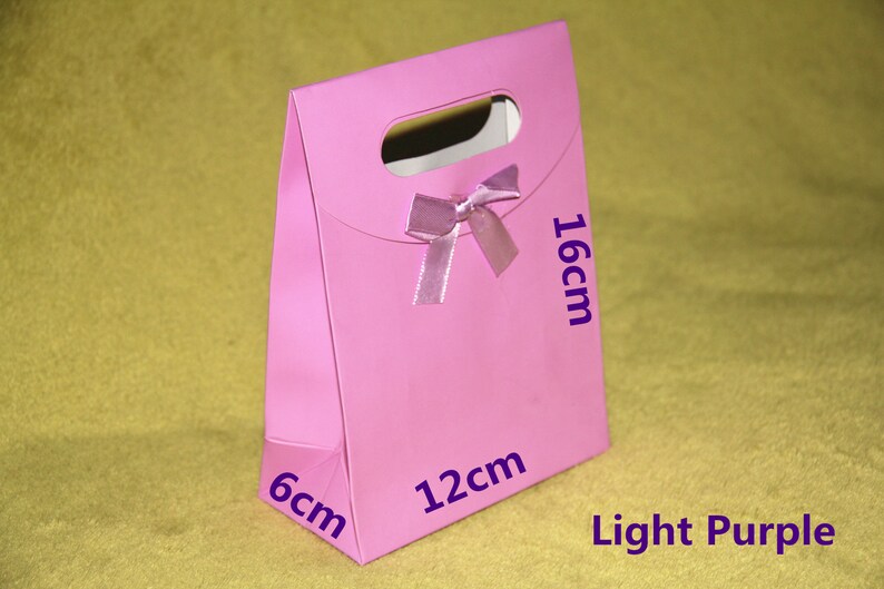 May include: Light purple gift bag with a bow, measuring 6 inches by 12 inches by 16 inches.