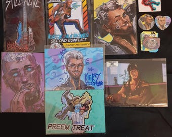 May include: A collection of art prints featuring illustrations of people and text. The prints are in various colors and styles, including black and white, blue and white, and red and white. The prints are displayed on a table with a white background.