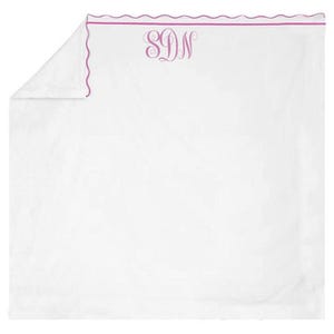 Puede incluir: Sábana blanca con borde festoneado y borde magenta. La sábana presenta un monograma en la parte superior central. El monograma consta de las letras S, D y N en una fuente decorativa.