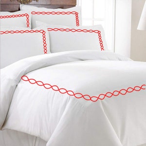 Puede incluir: Juego de cama blanco con ribete bordado rojo. El juego incluye una funda n&oacute;rdica y dos fundas de almohada.