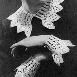 Könnte beinhalten: Ein weißer Häkelkragen und -manschetten mit einem zarten Spitzenmuster. Der Kragen hat eine spitze Form und die Manschetten sind breit und gekräuselt.