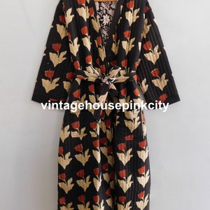May include: A black quilted robe with a floral print featuring red and cream tulips. The robe has a tie belt and two pockets.