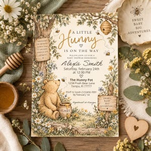 May include: A rectangular baby shower invitation card featuring a watercolor illustration of a bear sitting by a honey pot, surrounded by trees, flowers, and bees. The text reads A LITTLE HUNNY IS ON THE WAY, Alexa Smith, February 24th, and The Hunny Pot.