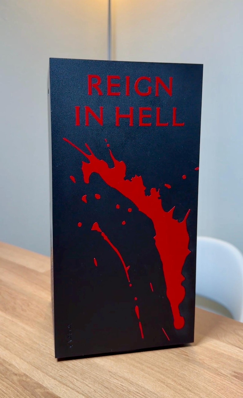 May include: Black box with the words "Reign in Hell" in red lettering. The box has a red splatter design.