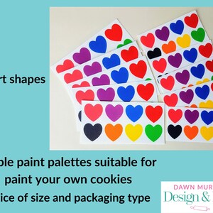 Puede incluir: Paletas de pintura comestibles con formas de coraz&oacute;n en varios colores, como rojo, azul, morado y amarillo. El texto dice "Heart shapes" y "Edible paint palettes suitable for paint your own cookies".