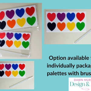 Puede incluir: Pegatinas en forma de coraz&oacute;n en varios colores, como rojo, morado, azul y verde. La imagen tambi&eacute;n muestra un pincel blanco. El texto de la imagen dice "Opci&oacute;n disponible para paletas empaquetadas individualmente con pinceles" y "Dawn Murphy Design & Bake".