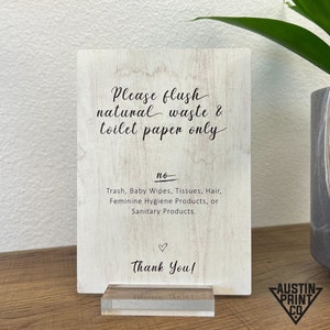 May include: A wooden sign with the text "Please flush natural waste & toilet paper only." Below, it lists items not to flush. The sign is on a clear acrylic base. The words "Thank You!" and a heart are at the bottom.