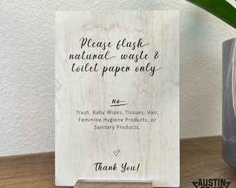 May include: A wooden sign with the text "Please flush natural waste & toilet paper only." Below, it lists items not to flush. The sign is on a clear acrylic base. The words "Thank You!" and a heart are at the bottom.