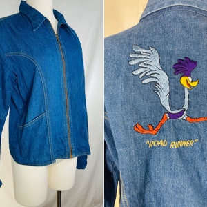 May include: A blue denim jacket with a zipper closure and a Road Runner cartoon embroidered on the back. The Road Runner is running and the text "Road Runner" is below it.