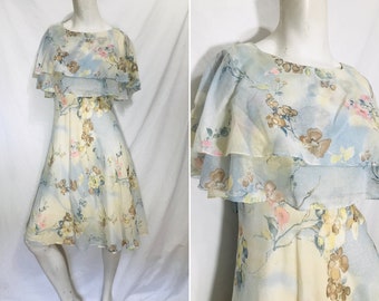 May include: A light blue and yellow floral print dress with a double-layered ruffle neckline. The dress has a fitted bodice and a flowing skirt.