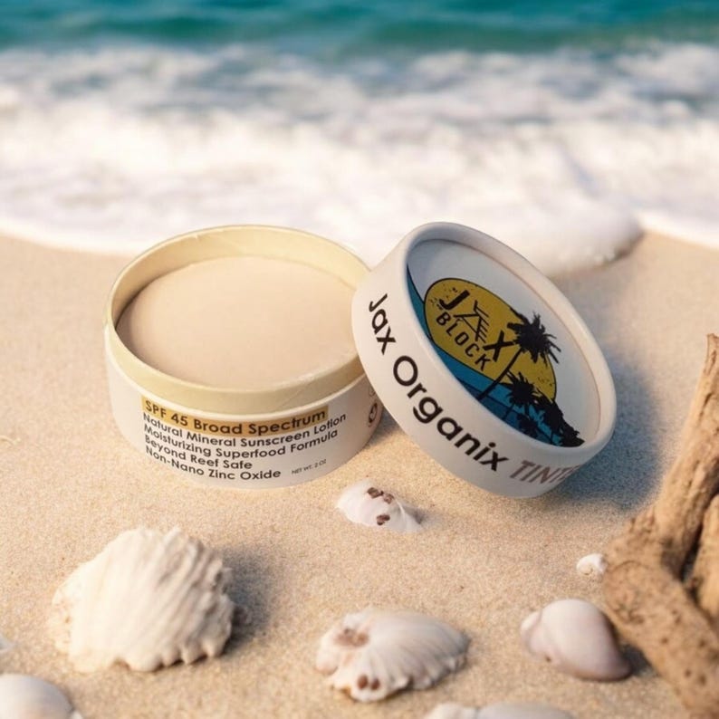 mineral sunscreen, open jar, sitting on sandy beach