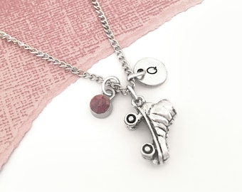 May include: Silver roller skate charm necklace with a pink gemstone and a silver initial charm. The initial charm is a letter "G".