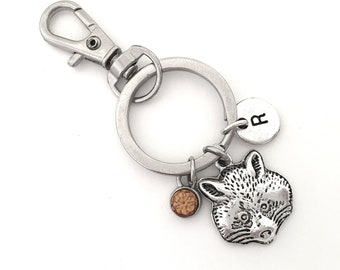 May include: Silver keychain with a raccoon charm, a small brown crystal charm, and a silver charm with the letter "R" on it.