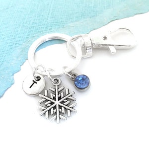 May include: Silver snowflake keychain with a blue crystal charm and a silver charm with the letter T.