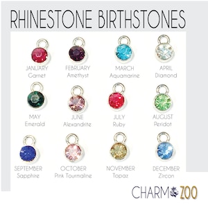 May include: A chart of birthstones for each month of the year. Each stone is represented by a small, round rhinestone charm. The chart includes the name of the month and the birthstone name.