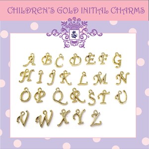 May include: A collection of gold-coloured initial charms, the alphabet from A to Z, presented on a white surface. The charms are in a cursive font and have a loop for attaching to jewellery. The text "CHILDREN'S GOLD INITIAL CHARMS" is at the top.