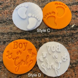 Pode incluir: Dois conjuntos de cortadores de biscoitos, um branco e um laranja. O conjunto branco tem duas pegadas e o texto "Boy or Girl?" O conjunto laranja tem duas pegadas e o texto "Boy or Girl?"
