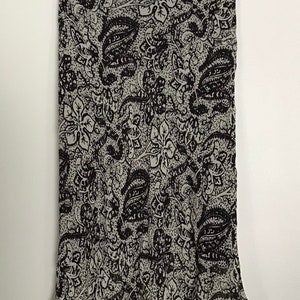 May include: A black and white paisley patterned skirt with a ruffled hem.