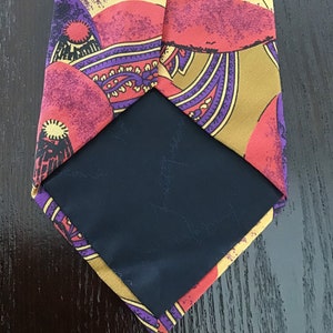 May include: A silk tie with a colorful paisley pattern in shades of red, yellow, purple, and brown. The tie has a black lining.