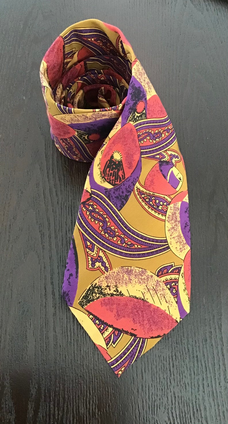 May include: A silk tie with a paisley pattern in shades of gold, purple, pink, and black.