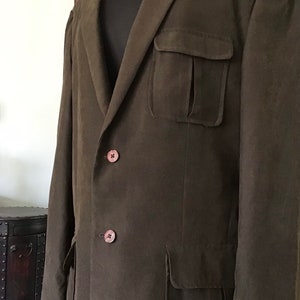 May include: A brown suede blazer with a single-breasted closure and two large flap pockets. The blazer has a relaxed fit and a long length.