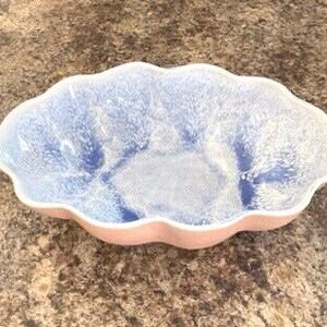 May include: A light blue and white ceramic serving dish with a scalloped edge and a pink base.