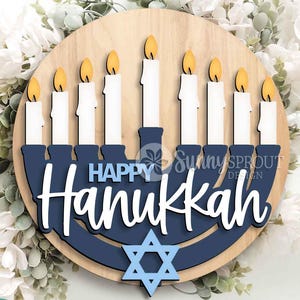 May include: A circular wooden sign featuring a layered navy blue menorah with nine white candles topped with yellow flames. The text "HAPPY Hanukkah" is displayed in white and blue script. A light blue Star of David is centered at the bottom.