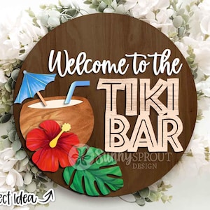 Puede incluir: Un letrero redondo de madera con las palabras "Welcome to the TIKI BAR". Presenta una bebida de coco con una sombrilla azul, una flor de hibisco roja y una hoja verde. Las palabras "Project Idea" están en la esquina inferior izquierda.
