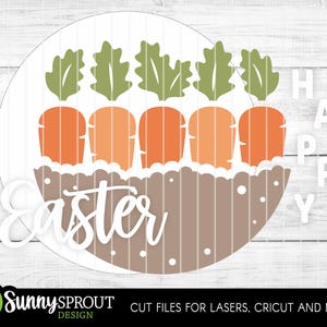 Pu&ograve; includere: Un design rotondo a tema pasquale di colore marrone e bianco con il testo "Happy" e "Easter" in bianco. Il design presenta cinque foglie verdi e cinque carote arancioni.