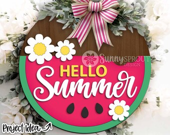 May include: A wooden round sign with a watermelon design and the text "Hello Summer" in white letters. The watermelon is red with green rind and black seeds. The sign is decorated with white daisies and a red and white striped bow.