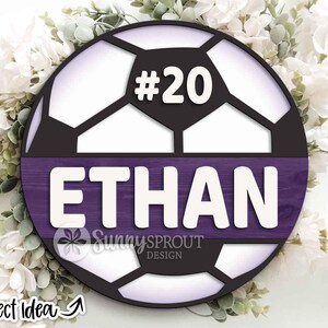 May include: A circular soccer ball design featuring the name "ETHAN" in white block letters on a purple panel. The number "#20" is above the name. The design includes the text "Sunny Sprout Design" and "Project Idea".
