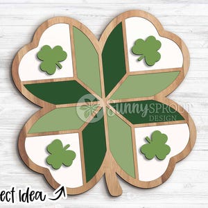 May include: Wooden four-leaf clover decoration with a light brown border. The clover is divided into sections of white, light green, and dark green. Each leaf has a green shamrock. The text "Project Idea" is at the bottom.