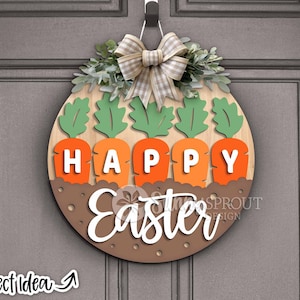 Pu&ograve; includere: Un appendiporta in legno con sfondo marrone e le parole "Happy Easter" in bianco. L'appendiporta &egrave; decorato con foglie verdi, un fiocco bianco e marrone e cinque carote arancioni con cime verdi.