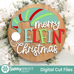 May include: A circular wooden sign featuring a layered design with a teal, red, and lime green elf hat and the text "merry ELFIN Christmas" in white, teal, and red lettering. The sign includes a white circular pom-pom accent on the hat.